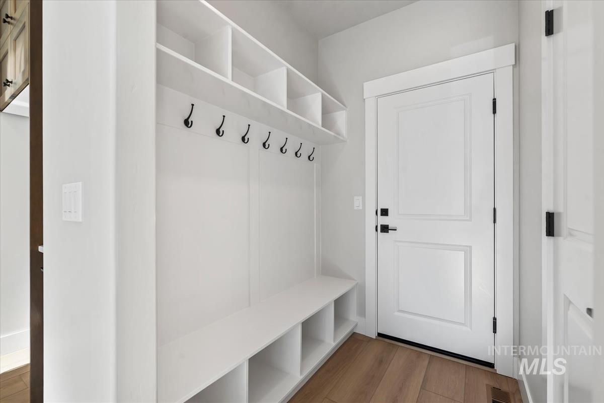 4223 Tropic Way Caldwell, ID 83607 - Photo 17 of 42 White built-in mudroom storage featuring a bench, shelving, and black coat hooks