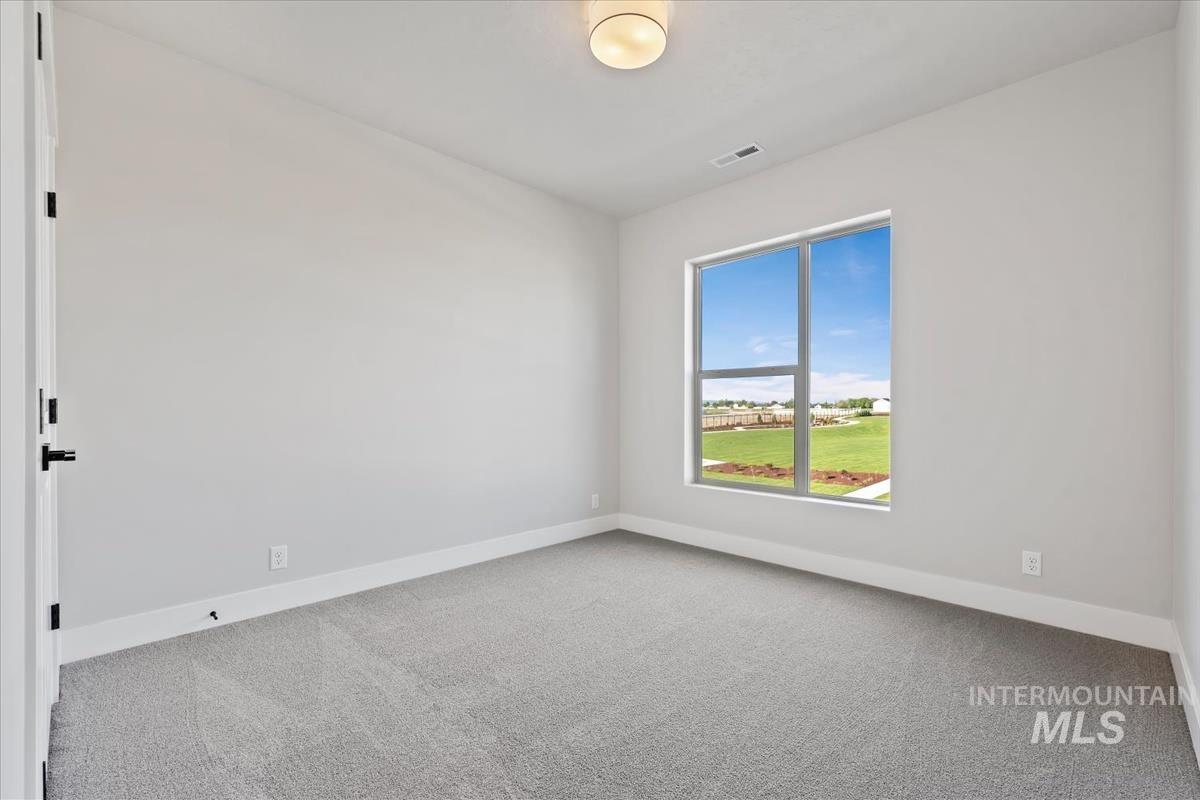 4223 Tropic Way Caldwell, ID 83607 - Photo 28 of 42 Spacious room featuring a large window, light gray carpet, white baseboards, and a contemporary flush-mount ceiling light