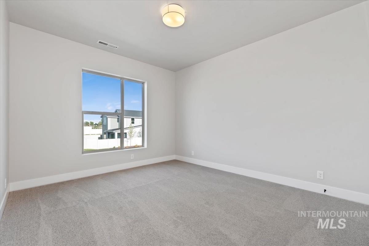4223 Tropic Way Caldwell, ID 83607 - Photo 29 of 42 Carpeted room with a large window, neutral wall paint, white baseboards, and a flush mount ceiling light
