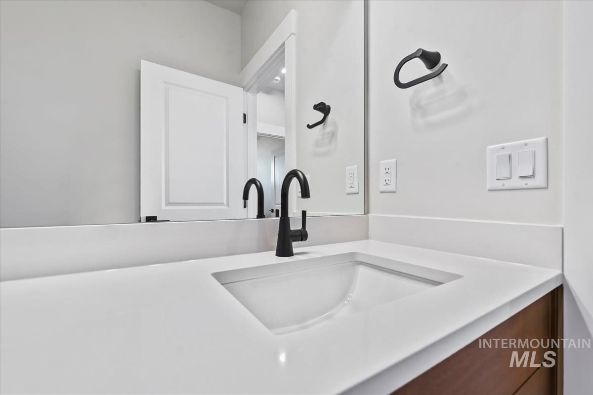4223 Tropic Way Caldwell, ID 83607 - Photo 31 of 42 Contemporary bathroom vanity featuring a rectangular undermount sink, a solid surface countertop, and a matte black faucet