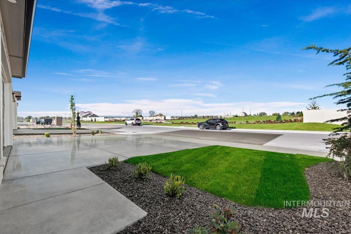 4223 Tropic Way Caldwell, ID 83607 - Photo 39 of 42 Concrete driveway and walkway with adjacent landscaping featuring river rock, manicured lawn, and low-growing shrubs