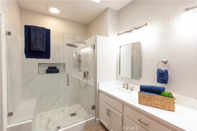 a bathroom with a shower sink and mirror