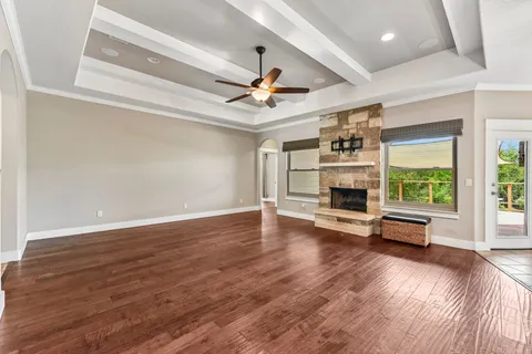 a view of a livingroom with furniture a ceiling fan and hardwood floor