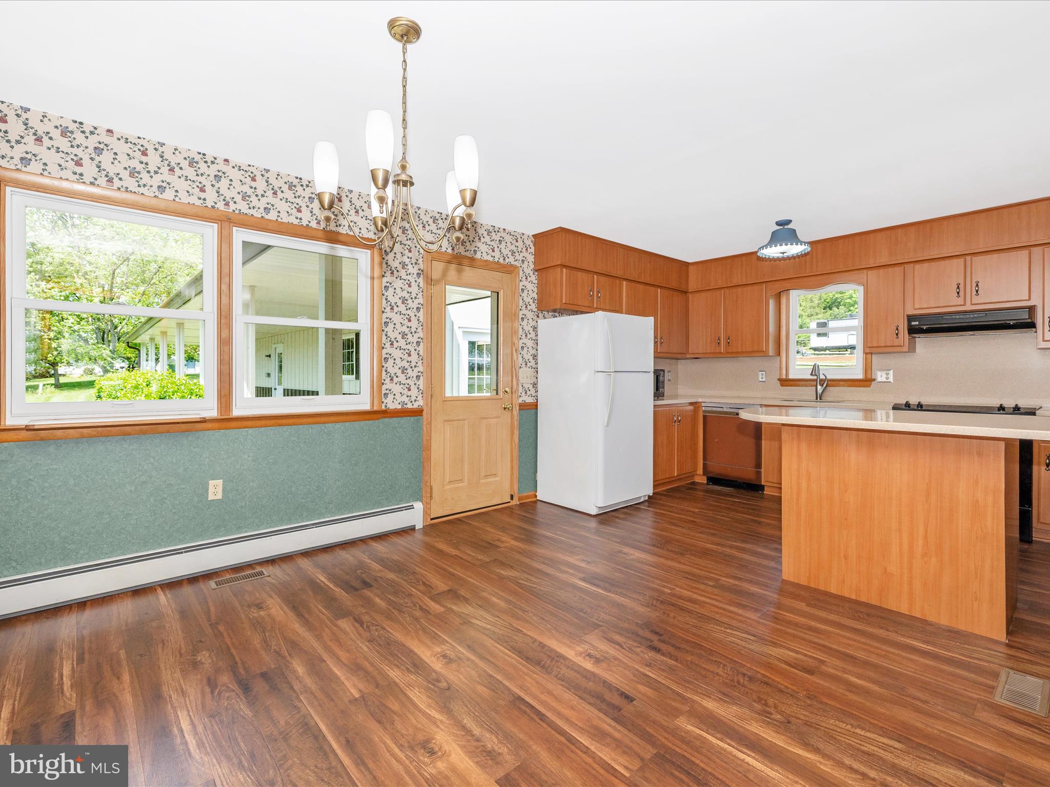 9203 Oak Tree Circle Frederick, MD 21701 - Photo 17 of 49 a view of a kitchen with a fridge wooden floor and a window