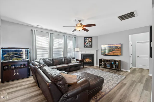a living room with furniture a fireplace and a flat screen tv