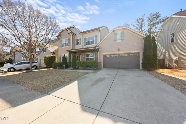 a view of a white house with a large trees