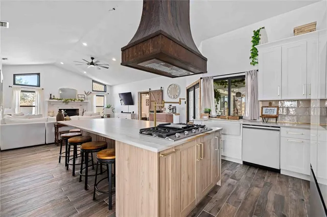 a kitchen with granite countertop a white stove top oven cabinets and wooden floor