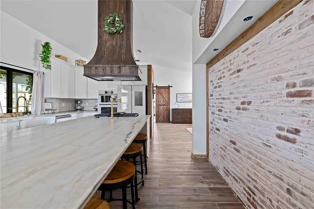 a kitchen with stainless steel appliances granite countertop a sink a stove and a refrigerator