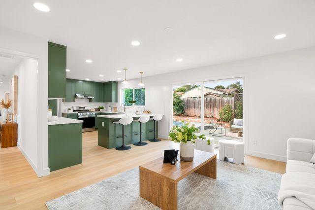 a kitchen with stainless steel appliances kitchen island granite countertop a sink and a refrigerator