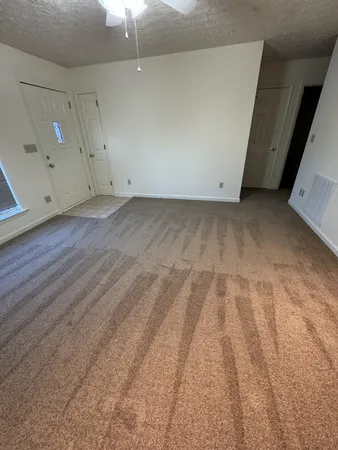 an empty room with fireplace and a chandelier