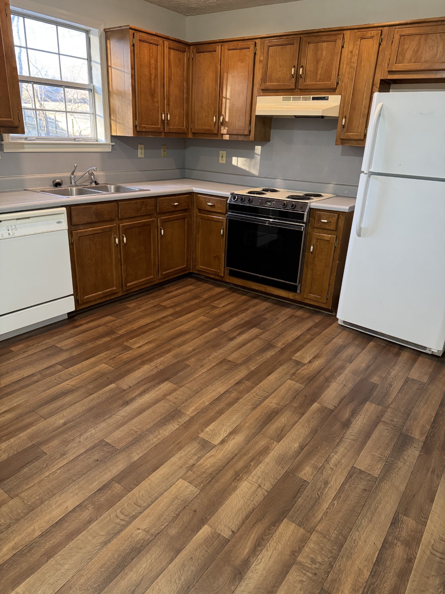 1714 Monument Lane, Unit B Lebanon, TN 37087 - Photo 6 of 9 a kitchen with stainless steel appliances granite countertop a sink dishwasher stove and cabinets with wooden floor