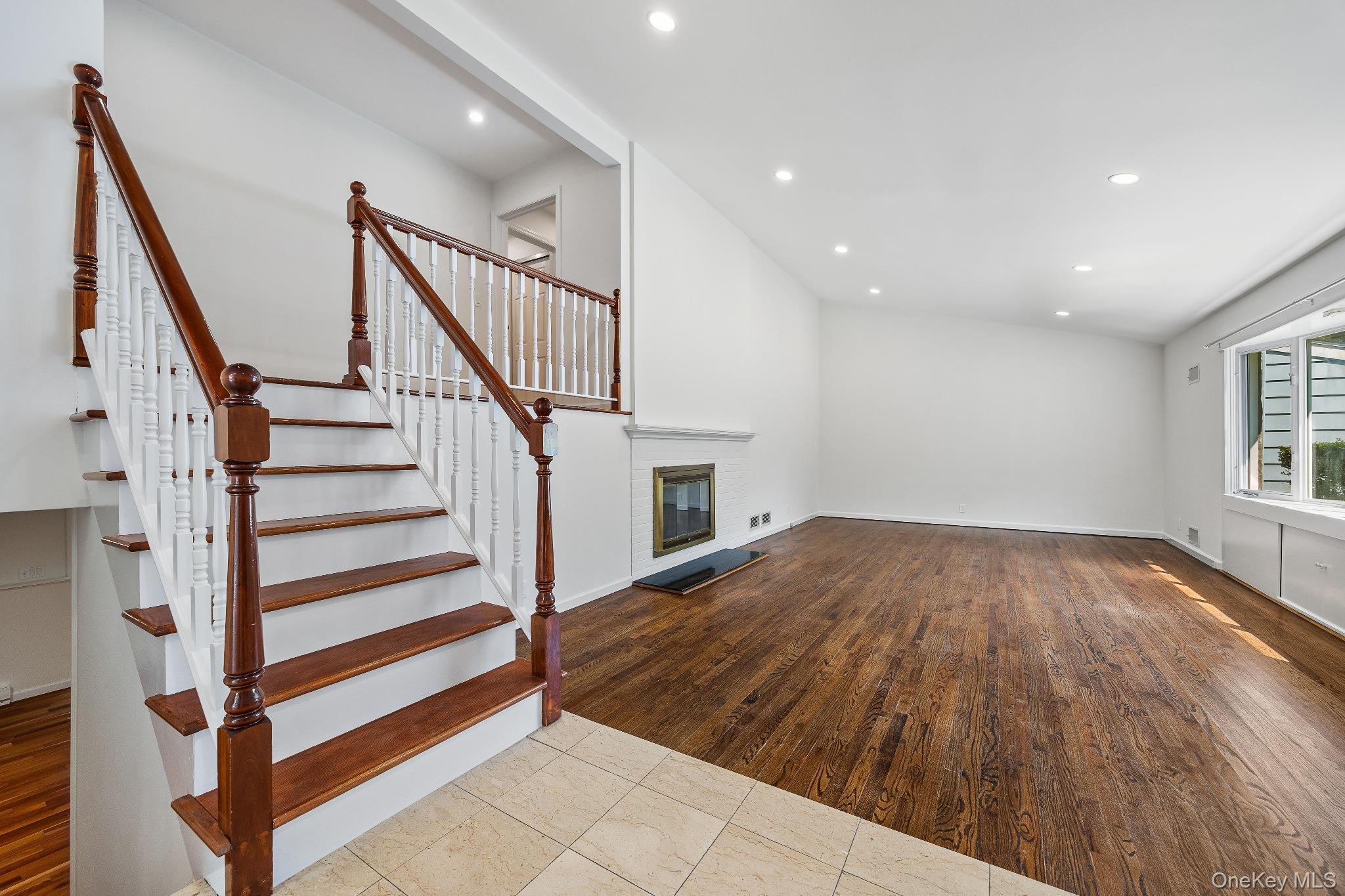 372 Heathcote Road Scarsdale, NY 10583 - Photo 8 of 20 Unfurnished living room with a brick fireplace, recessed lighting, wood finished floors, and stairway