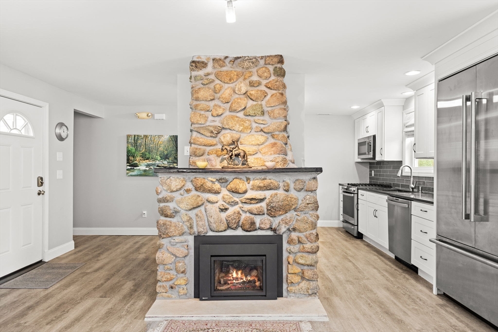 106 Circuit Avenue Wareham, MA 02571 - Photo 14 of 34 a open kitchen with granite countertop a stove top oven a refrigerator and a fireplace with wooden floor