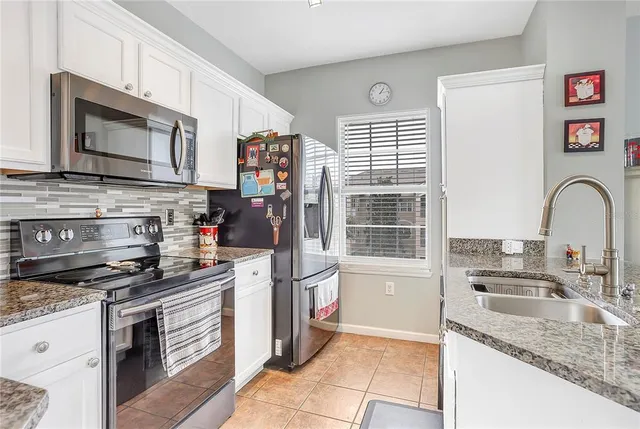 a kitchen with stainless steel appliances granite countertop a stove microwave and sink