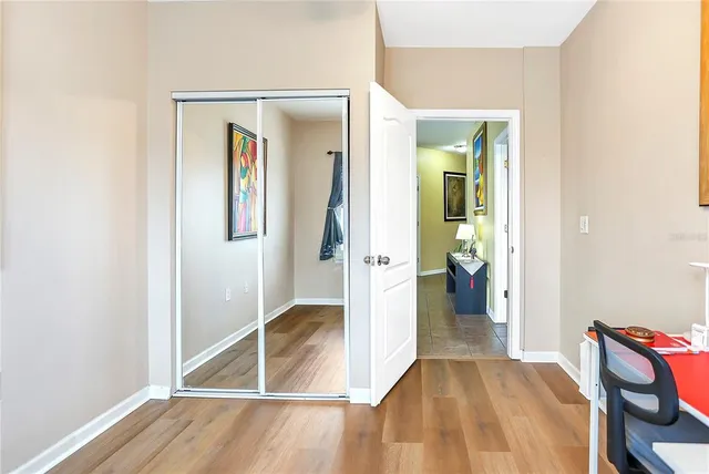 a view of a livingroom with wooden floor and a bathroom