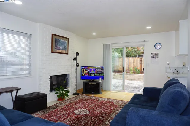 a living room with furniture a flat screen tv and a fireplace