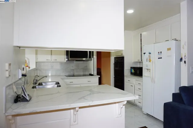 a kitchen with stainless steel appliances a sink and a refrigerator