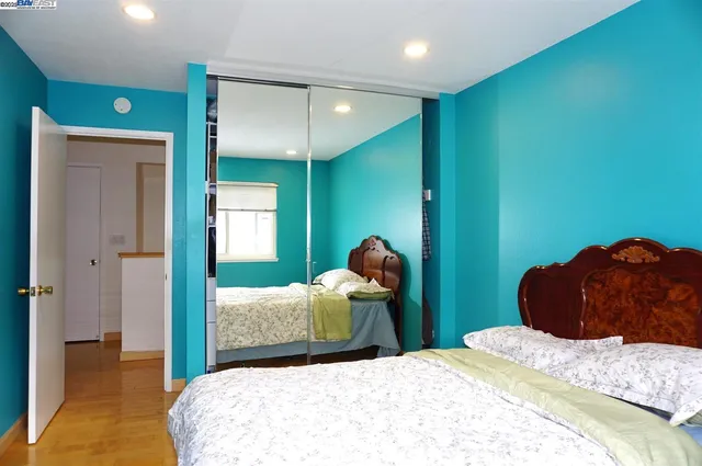 a bedroom with a bed and a large mirror