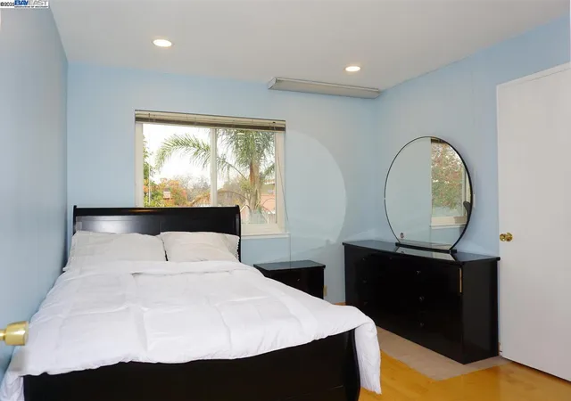 a bedroom with a bed and a large window