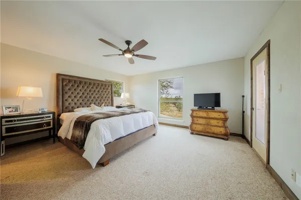 a bedroom with a bed a couch and a flat screen tv