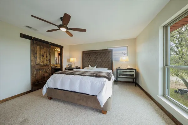 a spacious bedroom with a bed and large window
