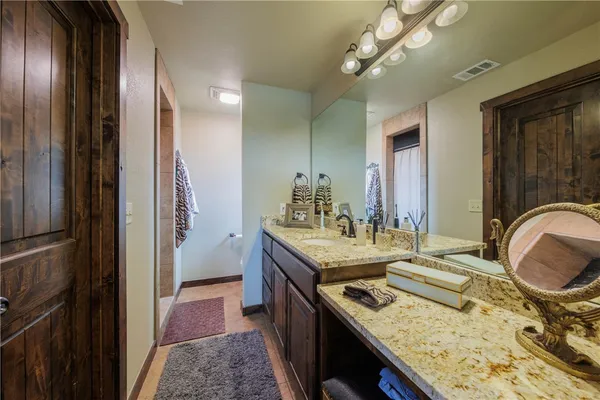 a en suite bathroom with a granite countertop sink and a mirror