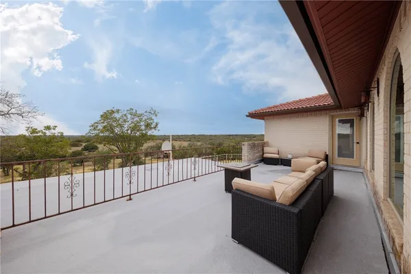 a roof deck with couches and sky view