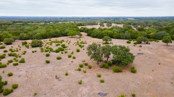a view of a field with trees in the background