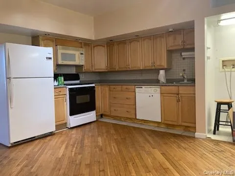a kitchen with a refrigerator sink and cabinets