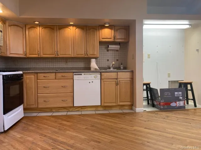 a kitchen with granite countertop a stove cabinets and wooden floor