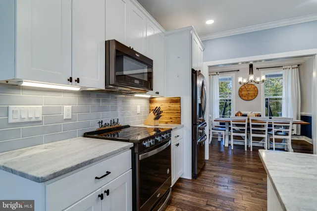 a kitchen with stainless steel appliances granite countertop a stove and a wooden floors