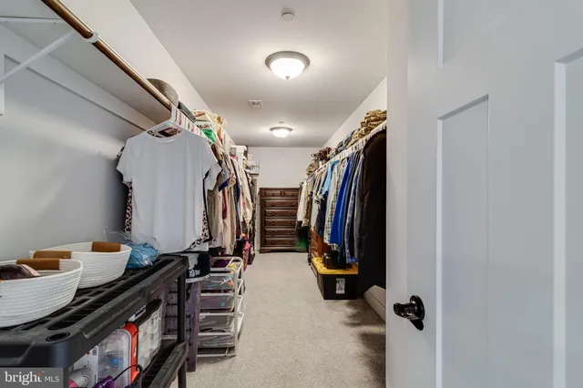 a view of walk in closet with clothes and shoes