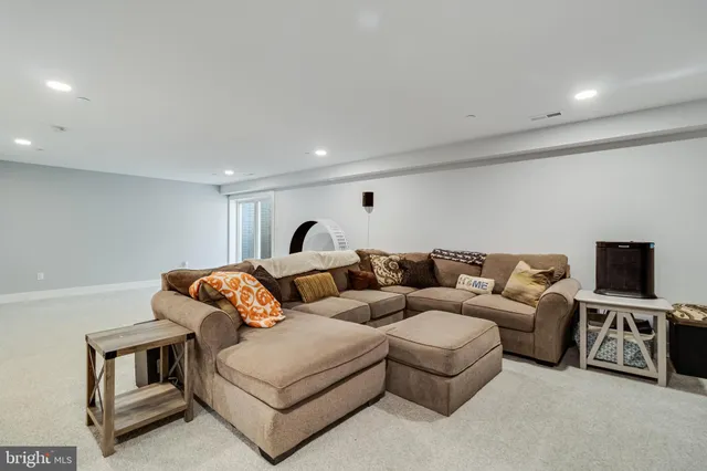 a living room with furniture a flat screen tv and a window