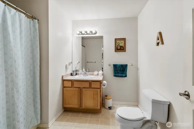 a bathroom with a toilet a sink and mirror