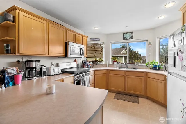 a kitchen with stainless steel appliances granite countertop sink stove and white cabinets