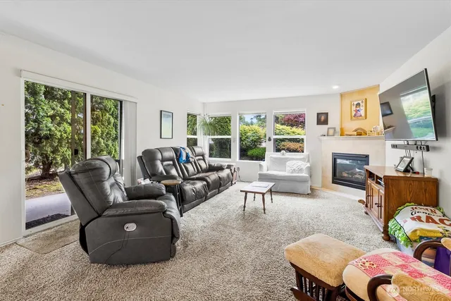 a living room with furniture a fireplace and a large window