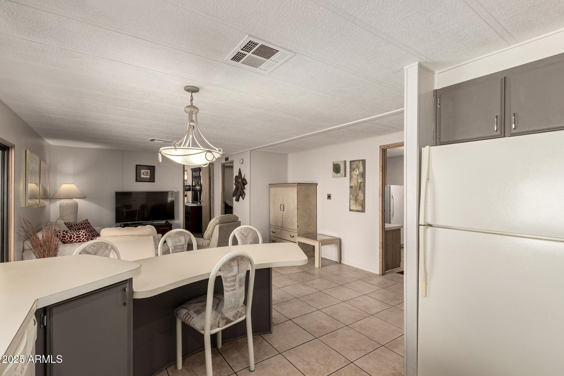 301 South Signal Butte Road, Unit 706 Apache Junction, AZ 85120 - Photo 21 of 51 a kitchen with a refrigerator a sink and chairs