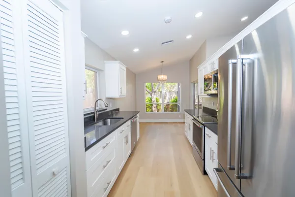 a kitchen with granite countertop a refrigerator and a sink