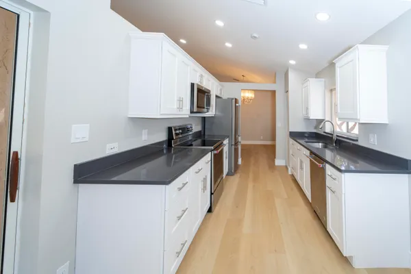 a kitchen with stainless steel appliances granite countertop a sink a stove and a refrigerator