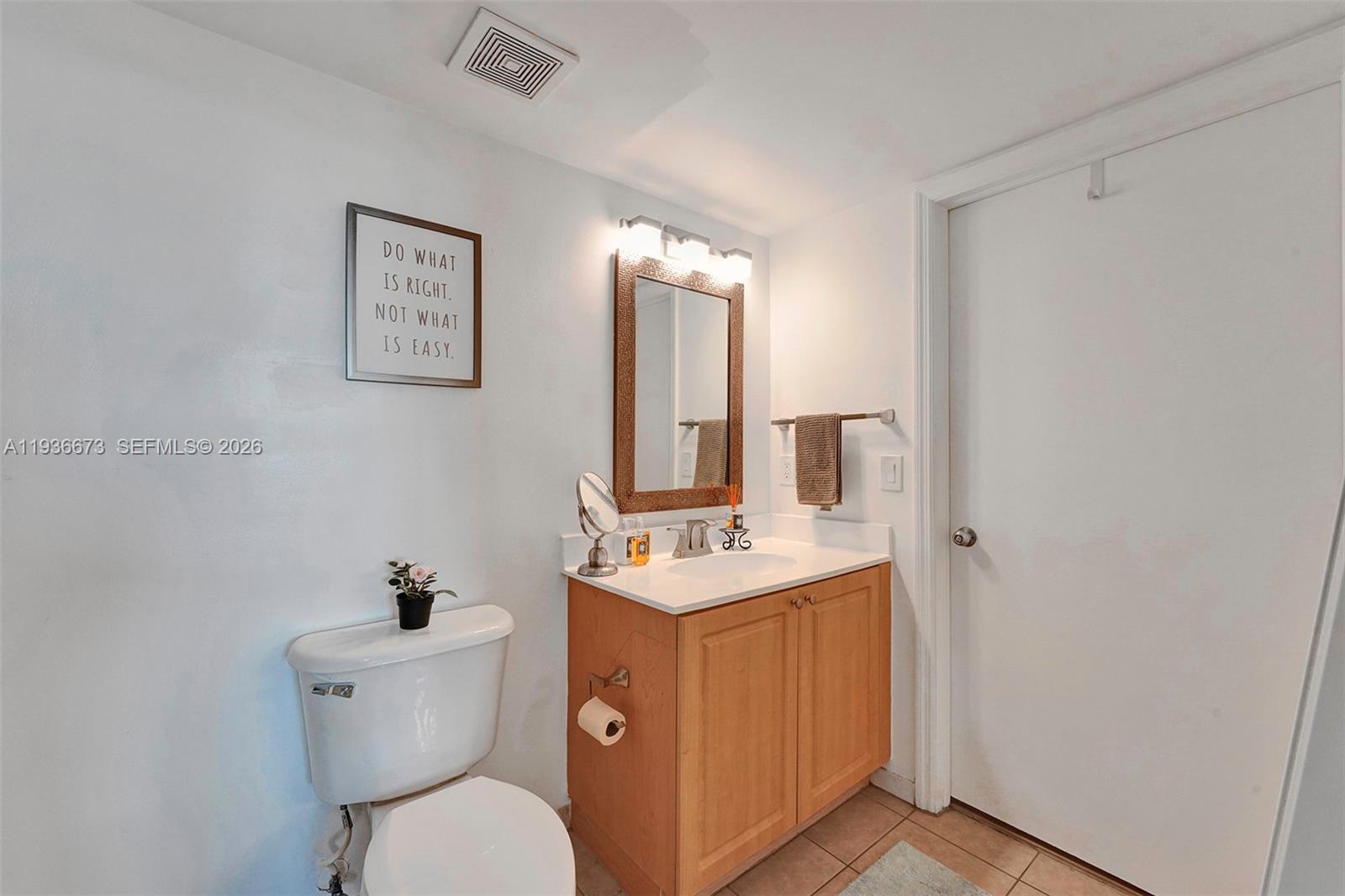 102 Southwest 6th Avenue, Unit 305 Miami, FL 33130 - Photo 11 of 16 a bathroom with a toilet sink and mirror