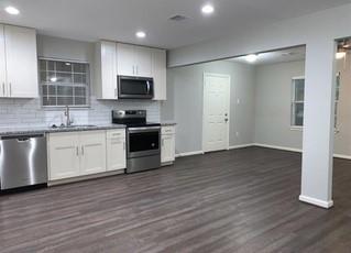 a kitchen with stainless steel appliances granite countertop a stove top oven a sink and dishwasher with wooden floor