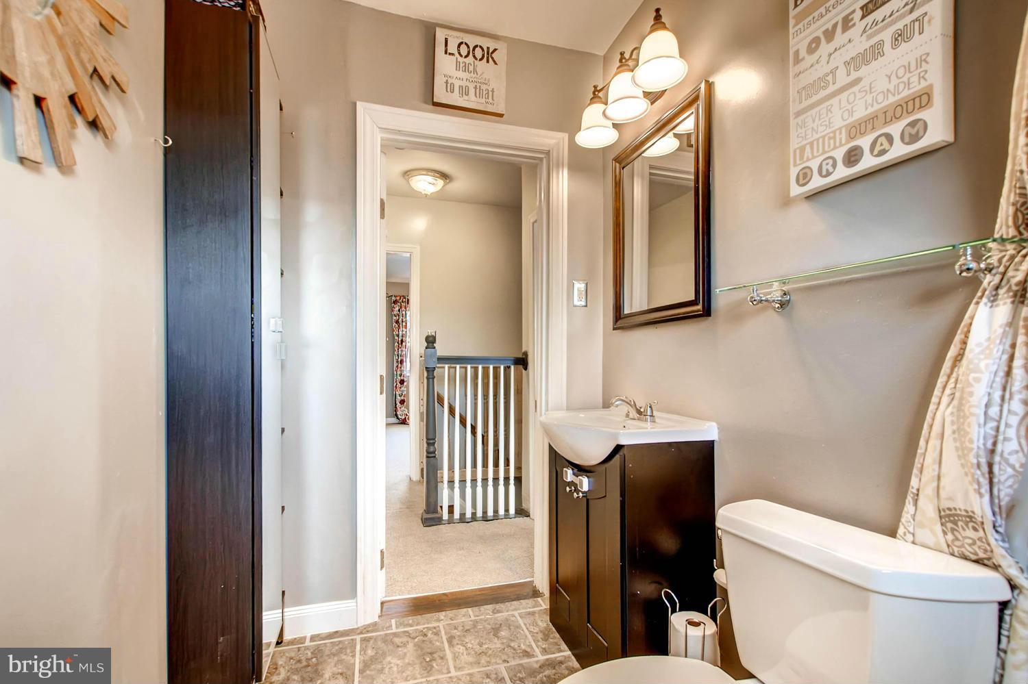 1950 Quentin Road Baltimore, MD 21222 - Photo 22 of 27 a bathroom with a toilet a sink and a mirror