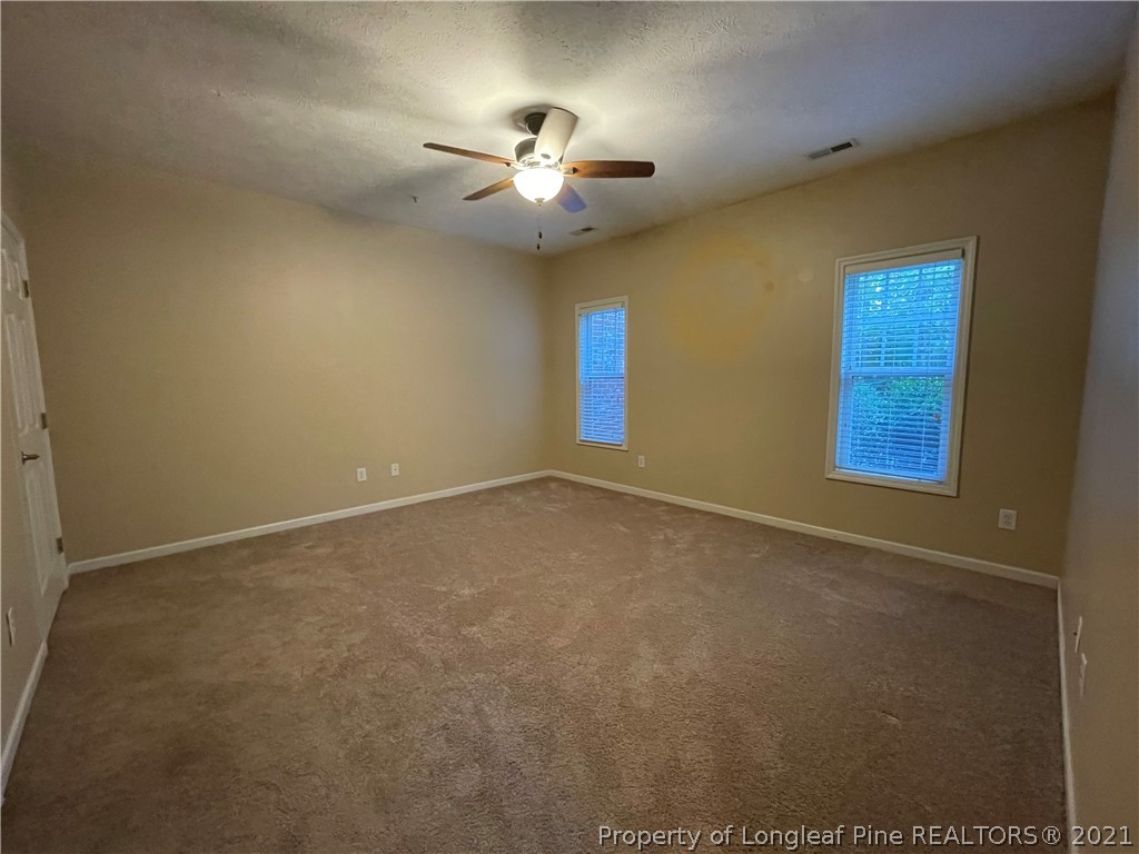517 Lionshead Road, Unit 4 Fayetteville, NC 28311 - Photo 8 of 19 an empty room with windows and chandelier fan