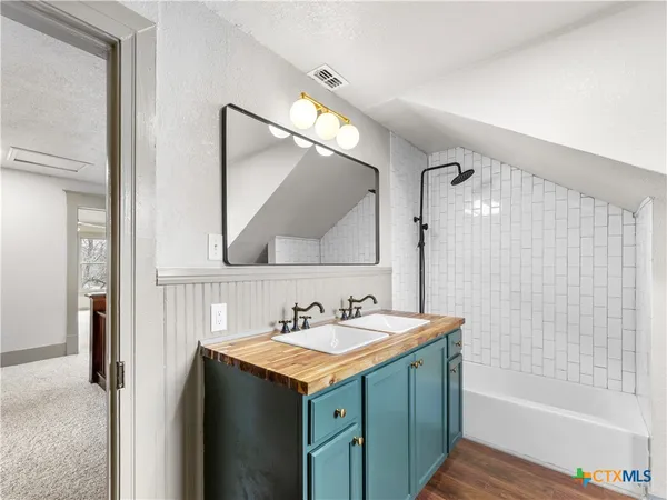 a bathroom with a granite countertop sink toilet and shower
