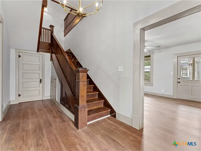 a view of a hallway with wooden floor and staircase