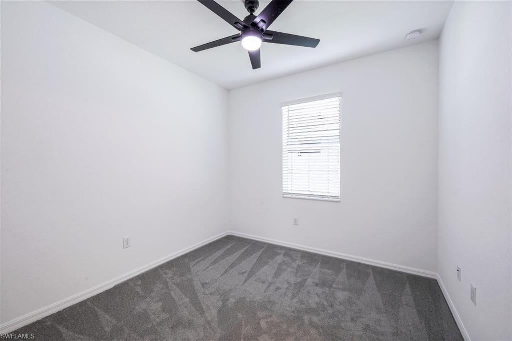 2434 Orchard Street Naples, FL 34120 - Photo 17 of 29 an empty room with a window and a fan