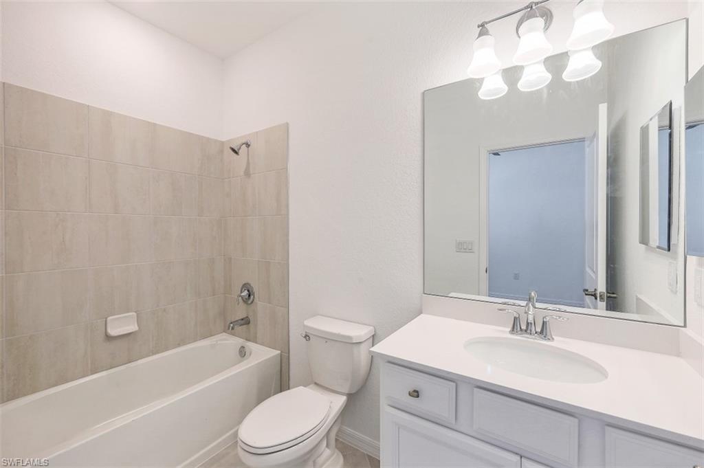 2434 Orchard Street Naples, FL 34120 - Photo 18 of 29 a bathroom with a sink a toilet and a mirror