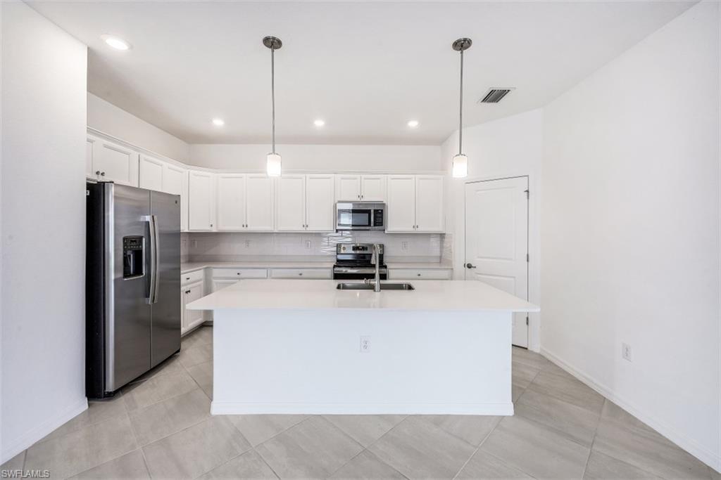 2434 Orchard Street Naples, FL 34120 - Photo 6 of 29 a large kitchen with stainless steel appliances granite countertop a sink a stove and a refrigerator