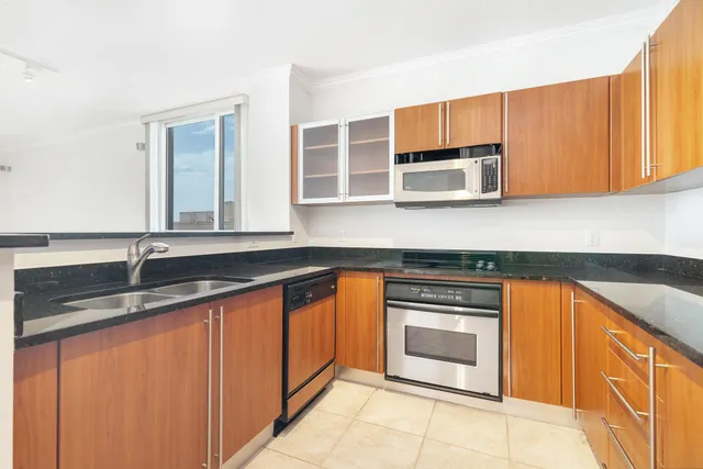 a kitchen with granite countertop stainless steel appliances a stove sink and microwave
