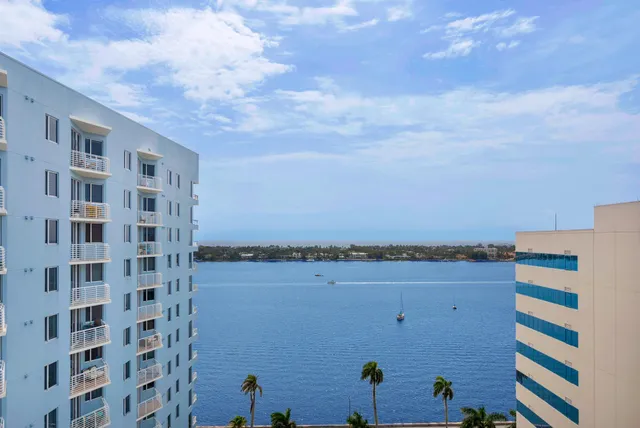a view of a building with lake view and tall buildings in the background